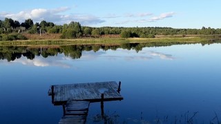 A guy in public pisses and jerks off his cock on the river bank, and a fisherman is fishing nearby