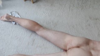 naked guy locked in chastity is caressing his cock.