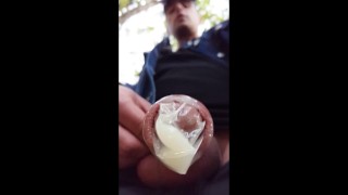 Boy walks with cum filled condom on his uncut dick after fuck outdoor