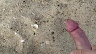 Horny twink jerks his big uncut cock on the beach 