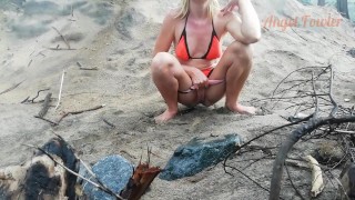 Public peeing teen girl on the beach