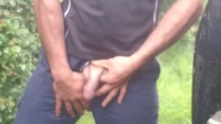 Hauls out cock and balls, pisses on the ground, in rubber boots and uniform