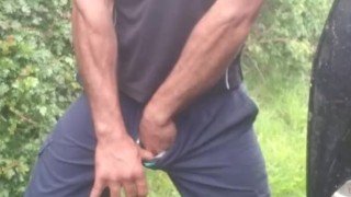 Hauls out cock and balls, pisses on the ground, in rubber boots and uniform