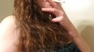 Sexy red head smoking and playing with titties 