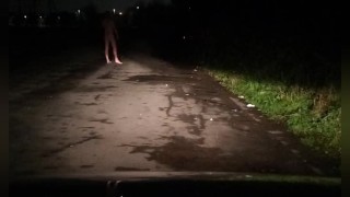 Risky nude on road with car passing 