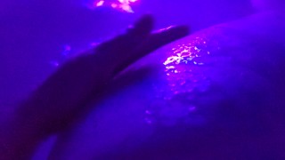Washing her cheeks in the bath with a blacklight