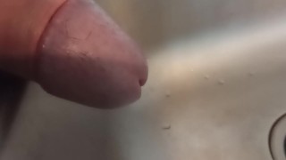 Close up of cock while pissing in the sink
