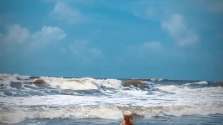 Tik Tok. Beach Voyeur looks on Blonde Teen enjoying Topless in the waves. 