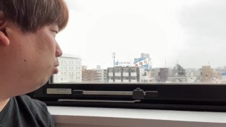 日暮里でホテルから見える景色を説明する男