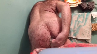 Hairy guy is satisfied in the bathroom.