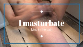 Japanese boy masturbates lying in the bath.