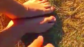 Solo guy rubbing feet in dirt outdoors
