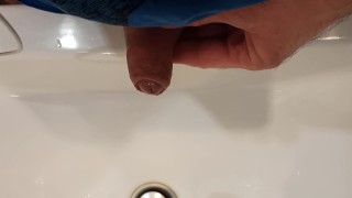 The boy is pissing into the washstand.