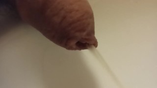 Extreme closeup pissing uncutted cock.