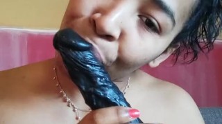 Sucking a big black dildo with saliva
