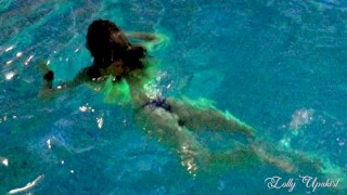 Girl with a sexy booty in a thong swims in the pool
