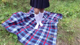 Schoolgirl in uniform shows legs feet foot in white knee socks and pantyhose under skirt