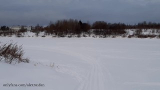 Russian guy walks in the snow near the river, pissing in the snow, he was noticed by a strange guy