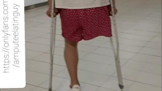 Amputee guy walking around with crutches