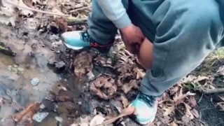 teen pissing in a forest stream after a run