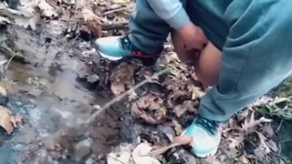 teen pissing in a forest stream after a run