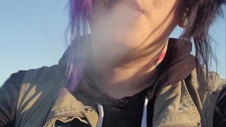 Alternative girl smoking cigarettes on the beach