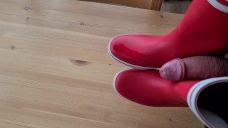 Cumming on her red rubberboots