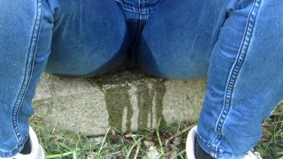 Pissing jeans in public street in sunny day