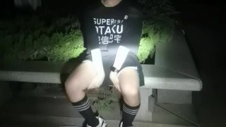 公園で通行人に彼の手の中毒を示す黒いストッキングのかわいい