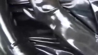 Latex girl full in black rubber and Gasmask chill outs outdoor in garden in a heavy rubber hammock