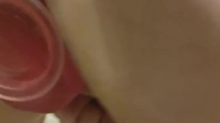 Squirting by being ficked with a pink dildo stick to a glass shower.
