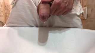 Gay stud twink pissing in a sink with a hard uncut dick