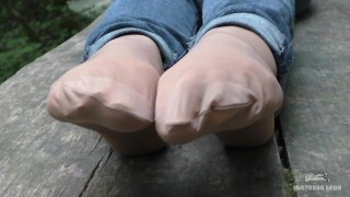 Jeans Feet In Nylon Socks In The Forest
