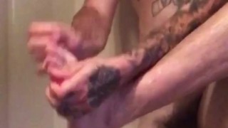 Hot tattooed guy massages his own cock and prostate in shower 