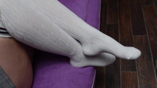 Сексуальная школьница одевает белые гольфы и показывает свои стопы