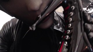 Sucking and spitting heels and dildo in silicone mask and black nylon encasement