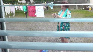 Neighbor in bathrobe without panties and bra dries washing courtyard, neighbour watching out window