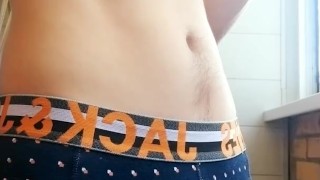 a guy with a beautiful body and a big dick in panties smokes on the balcony