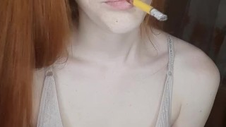redhead girl smokes a cigarette