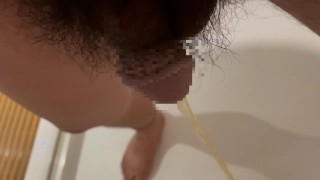 Chubby Japanese guy pees in the bathroom drain