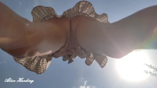 Alice in nature without panties upskirt shows her pussy by putting the camera in the grass