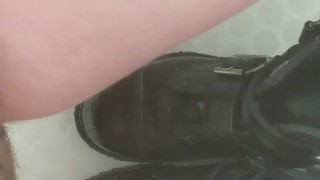 Girl pisses on her black combat boots
