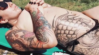 Hot inked girl playing with her big boobs next to the pool