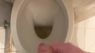 a guy pisses and then masturbates in the bathroom, cumming with his nice cock all over the place