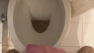 a guy pisses and then masturbates in the bathroom, cumming with his nice cock all over the place