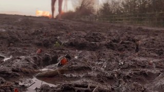 Naked barefoot muddy field