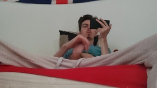 Twink jerks off his big cock and ejaculates while watching a porno