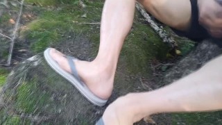 Twink wearing gray flip flops short shorts walks relaxes wanks his cock near water in public outdoor