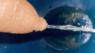 Pissing into bathroom commode 