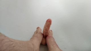 Jeune mec branle un sextoy (gode) avec ces pieds et ces mains 